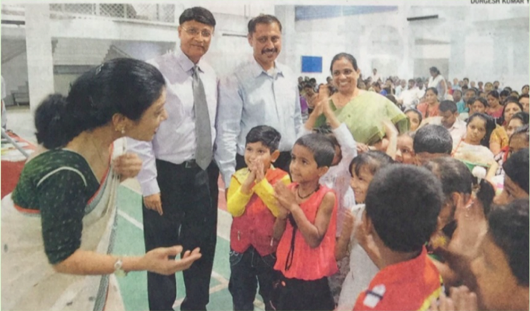 Dr. Deepak Shah with children and families at a community homeopathy event